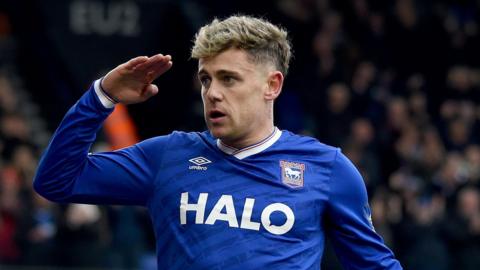 Sam Szmodics giving a salute as he celebrates scoring a goal for Ipswich Town