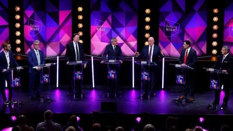 Scottish party leaders in a BBC studio for a Debate Night taping. John Swinney is speaking animatedly.
