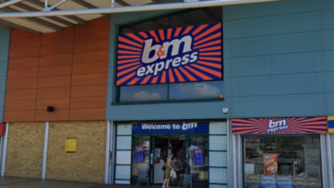 An exterior view of the shopfront of a B&M Express store, which has an orange and blue sign and is situated in a retail unit with turquoise cladding. 