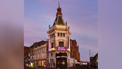 A CGI image of how the front of the theatre would look, with new lighting. The theatre is pictured at dusk.