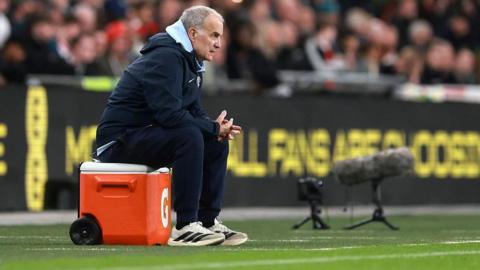 Uruguay head coach Marcelo Bielsa watches while sitting on a upturned cool box
