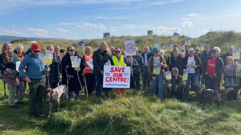 Protesters holding placards, including one that says "Save Our Centre" 