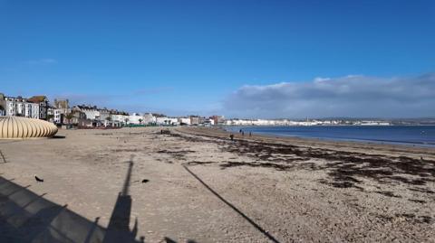 A beach with blue skies and blue water.