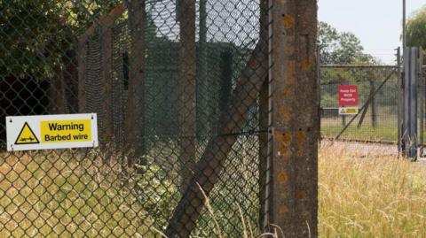 Barbed wire fencing around a former military site near Piddington in Oxfordshire.