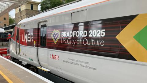 An LNER train with the words "Bradford 2025 UK City of Culture" on the side.