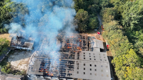 An aerial shot of a barn fire 