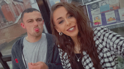 A man and a woman are pictured, with the man sticking out his tongue