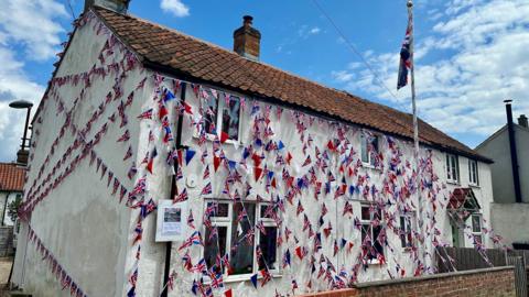 Mr Gunston's home coverd in flags and coloured red, white, and blue 