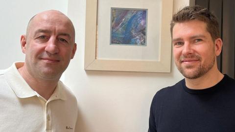 Steve Gallant (left) and Darryn Frost in front of a picture by Anne Merritt, the mother of Jack Merritt