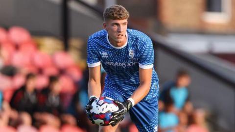 Jordan Wright looks to roll the ball out while playing for Grimsby Town