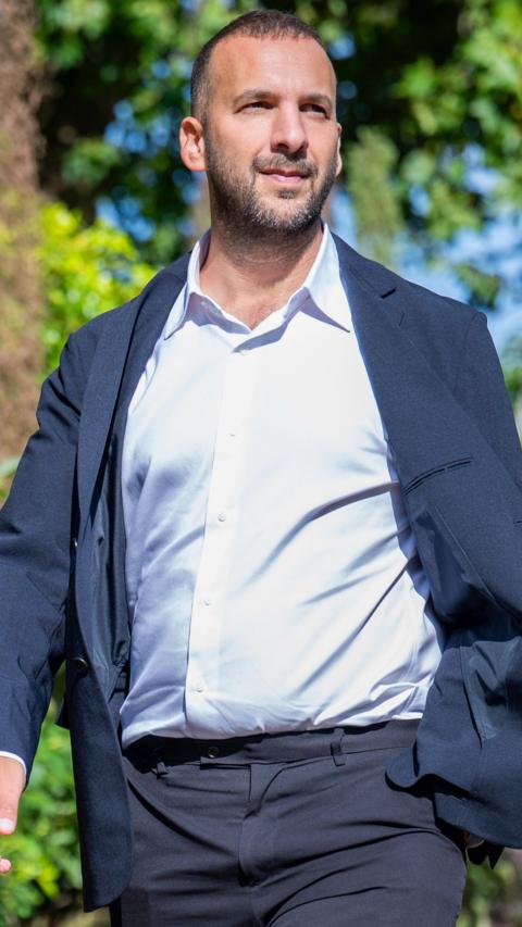 Green Party leader Zack Polanski wearing a white shirt, and a navy jacket
