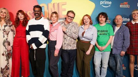 Roisin Conaty, Diane Morgan, Romesh Ranganathan, Mel Giedroyc, Alan Carr, Amy Gledhill, Sam Campbell, Bob Mortimer and Maisie Adam line up for a photocall in front of a Last One Laughing 2-branded background.