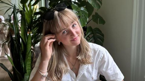 Handout photo of Erin Cruickshank smiling at the camera, wearing a white shirt