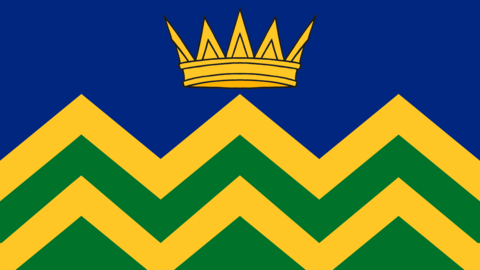 A flag design showing A gold crown, on a blue background above a yellow and green zig-zag pattern.