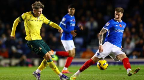 Wrexham's Josh Windass (L) crosses the ball