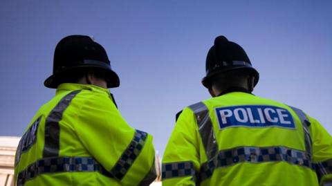 Two police officer pictured from behind