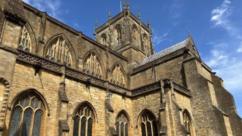 View of Sherborne Abbey  - medieval sandstone church building with bell tower