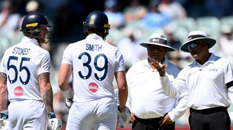 Ben Stokes and Jamie Smith discuss the decisions with the umpires 