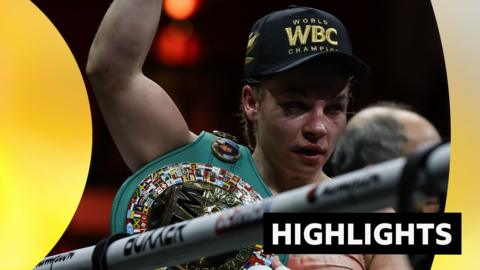 Lauren Price face is bruised after beating Stephanie Pineiro. She holds arm up and wears a WBC champion cap.