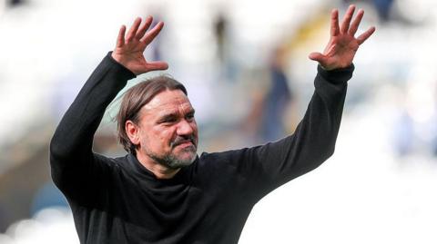 Daniel Farke with his arms in the air acknowledging the fans