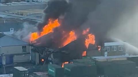 Flames and smoke emerged from a building in the middle of the picture