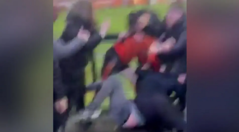 A number of blurred shapes which appear to be people, possibly grappling each other or falling over
