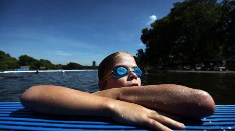 A child swimming in a Lido in the Serpentine Lake, London