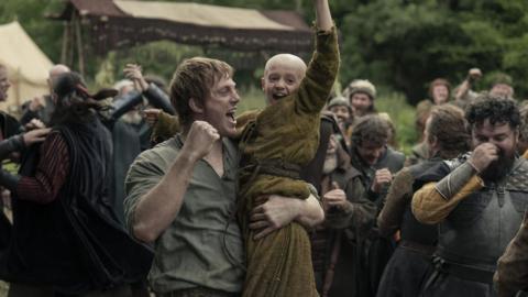 A Knight of the Seven Kingdoms - Image of two people celebrating in a scene of soldiers in field.