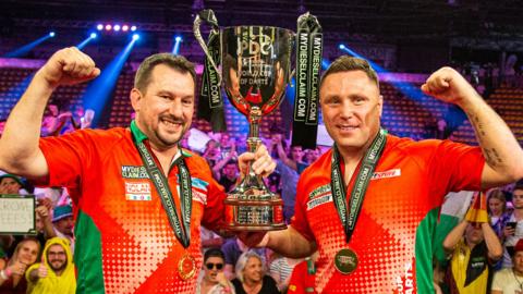 Jonny Clayton (left) and Gerwyn Price (right) with the World Cup of Darts trophy in 2023