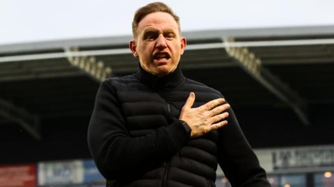 Shrewsbury Town boss Gavin Cowan slaps his chest in celebration