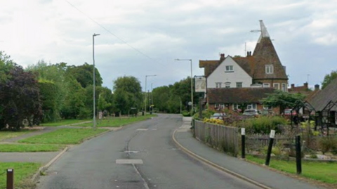 A Google street image of a two-way road with a pub on the right.