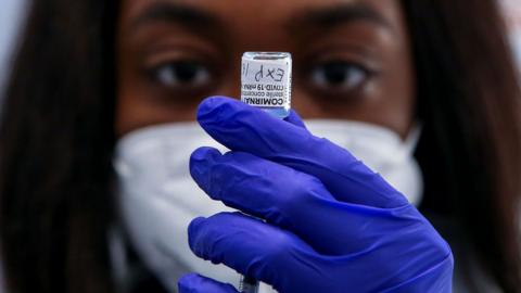 A NHS vaccinator draws the Pfizer COVID-19 second booster jab (fourth dose) to be administered to a woman, at a vaccination centre in London. Older adults have been invited for a fourth Covid-19 dose as part of the spring Covid-19 booster campaign in 2022