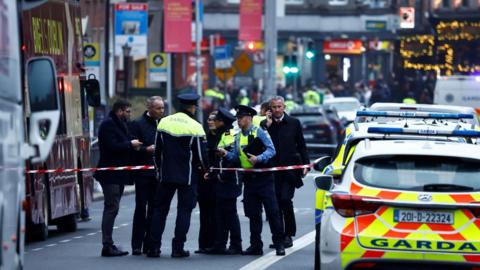 Police officers work at the scene of a suspected stabbing that left few children injured in Dublin, Ireland,