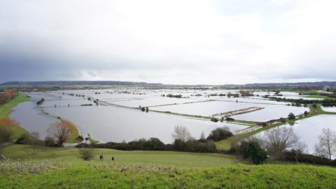 A large landscape shows fields underwater.