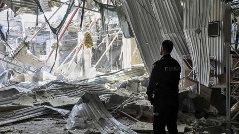 A man looks out from a blown-up building following strikes in Odesa, Ukraine