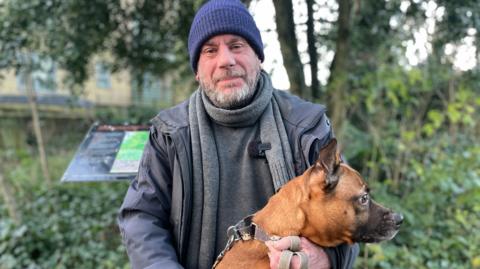 Paul and his dog Cally sitting in a park 