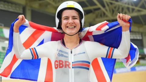 Daphne Schrager smiling holding a British flag