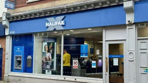 A former Halifax Bank premises, with a blue Halifax sign above a large window and door. A cash machine is to the left.