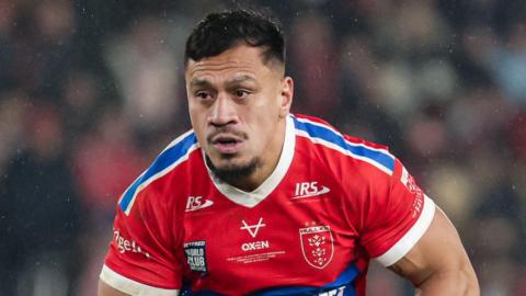 Sauaso Sue carrying the ball in his left hand as he prepares to run at an opponent