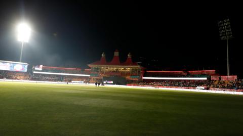A single floodlight on at the cricket ground in Dharamshala 