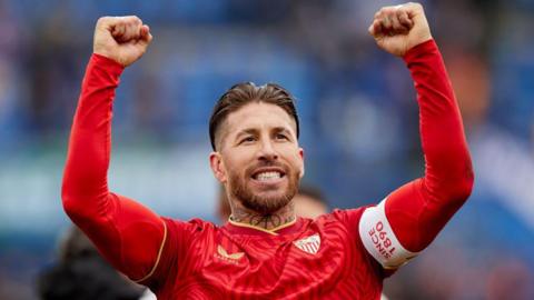 Sergio Ramos holds his arms up in the air