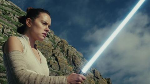 Rey from Star Wars looking concerned holding a light saber