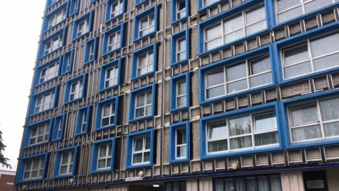 Leamington House, a grey tower block with blue window frames.