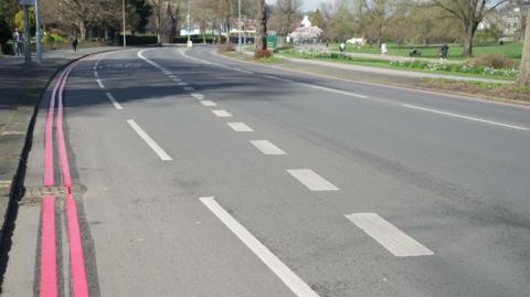 The A23, with double red lines painted on the side