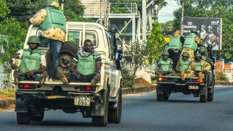 Soldiers ride on the back of army pickups in Freetown, Sierra Leone - 27 November 2023