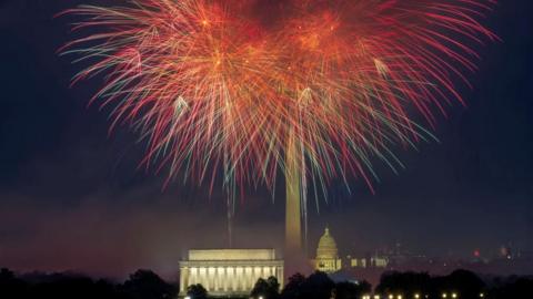 Fireworks erupt over the Washington, DC skyline at night.