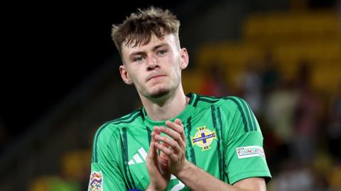 Conor Bradley applauds supporters after the game