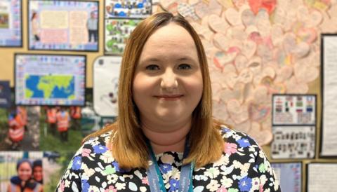 School teacher Rebecca Laird standing in front of a school notice board 