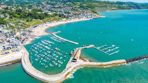 A general view picture of Lyme Regis and its harbour on a clear summer's day.