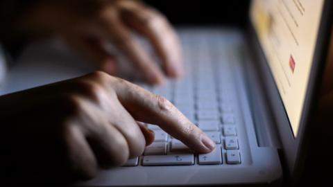 A person types on a laptop.